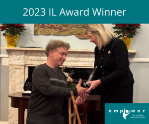 Photo of her Honour the Lieutenant Governor of Newfoundland Labrador, the Honourable Joan Marie Aylward with award winner Paul Power, shaking hands. Title reads 2023 IL Awards Winner. The Empower logo is in the lower right corner. 