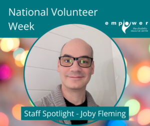 A photo of Joby Fleming, Empower's Advocacy Services Manager sits over colorful party lights in the background. Title reads National Volunteer Week and text reads Staff Spotlight - Joby Fleming. The Empower logo is in the upper right corner.