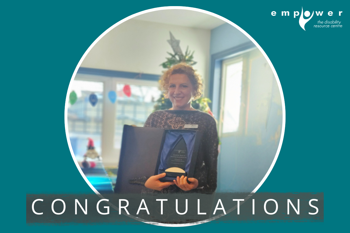 Photo of Marta Evstigneev accepting the Community and Social Inclusion Award on behalf of the Canadian Hard of Hearing Association NL. Text reads Congratulations! The Empower N L logo is in the upper right corner.