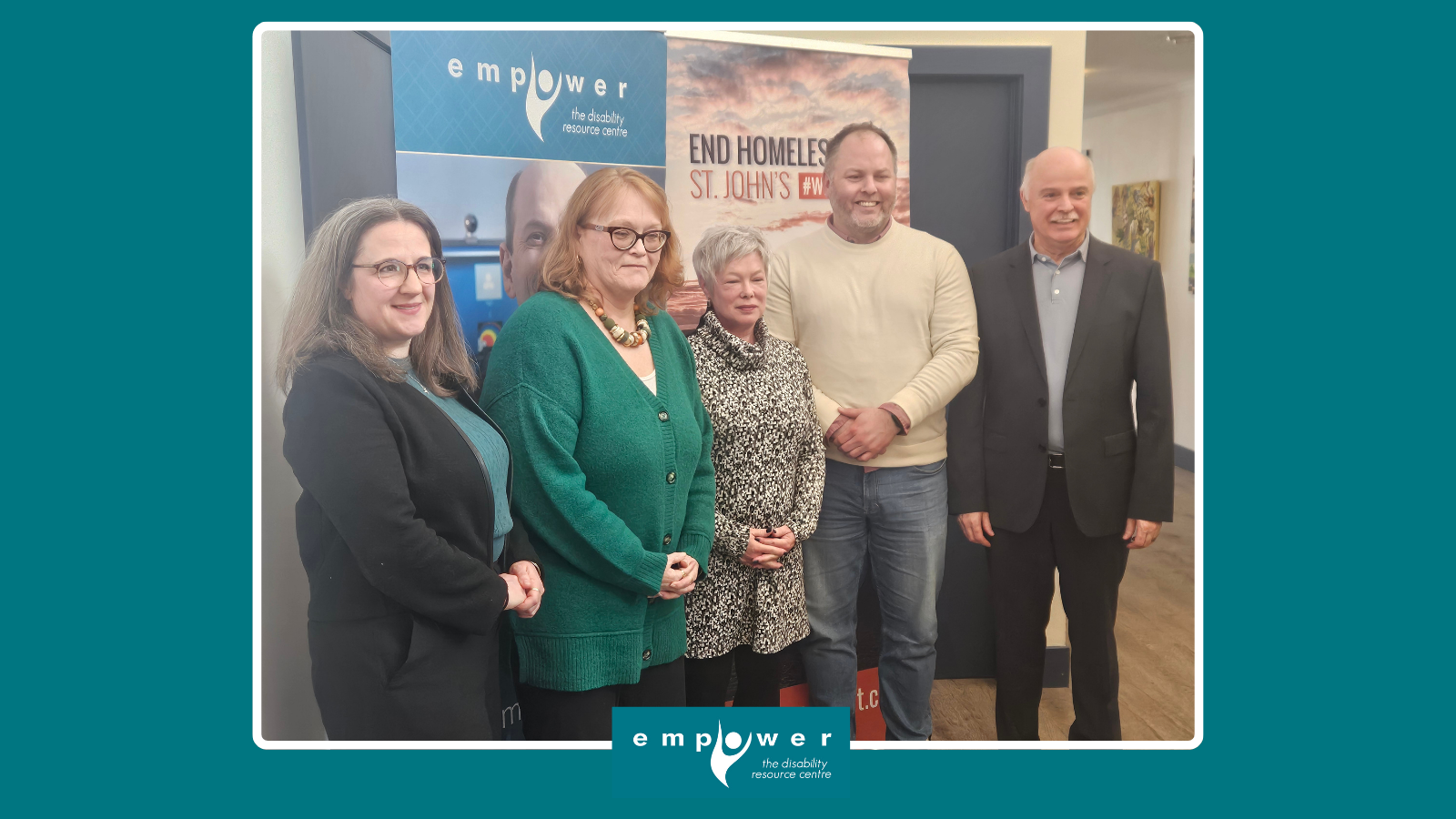 Photo of Jennifer Tipple (EHSJ), Kathy Hawkins (EmpowerNL), Chantal Perry (CAEH), Doug Pawson (EHSJ) and Mr. Tom Osborne, MP for Cape Spear posing in front of EmpowerNL and EHSJ banners. The Empower N L logo is centered at the bottom.